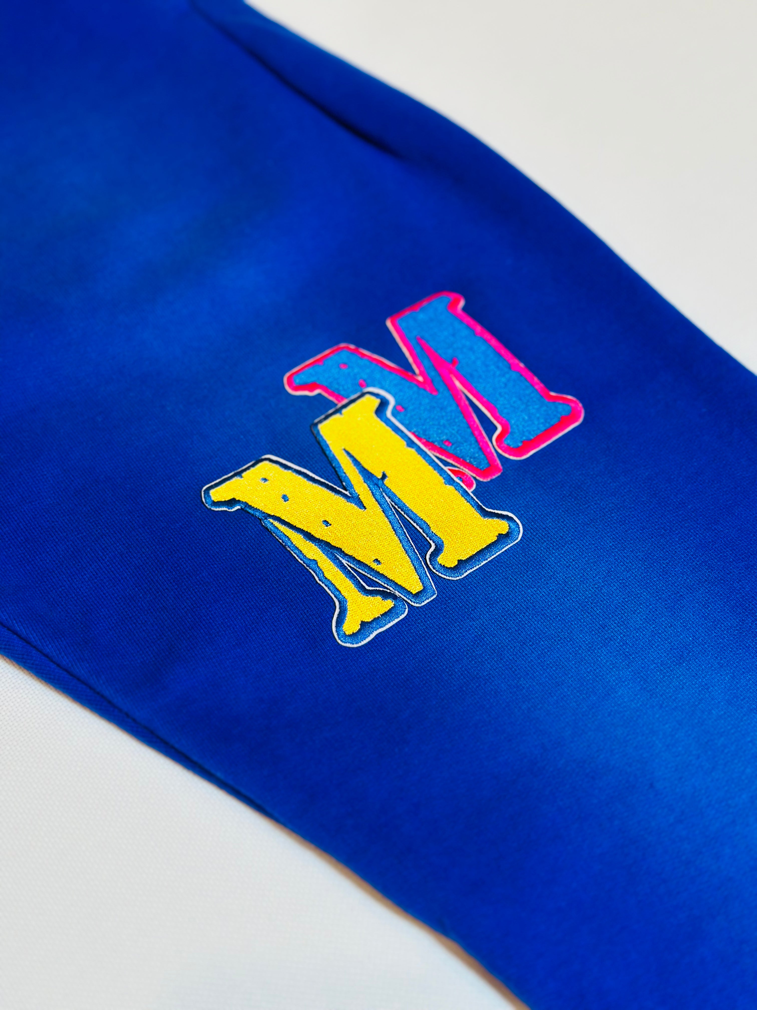 Blue fabric with a colorful 'MM' logo on a light gray background