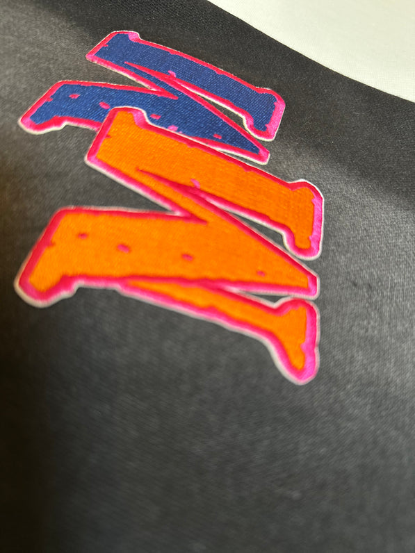 Colorful letter 'M' patch on a black background